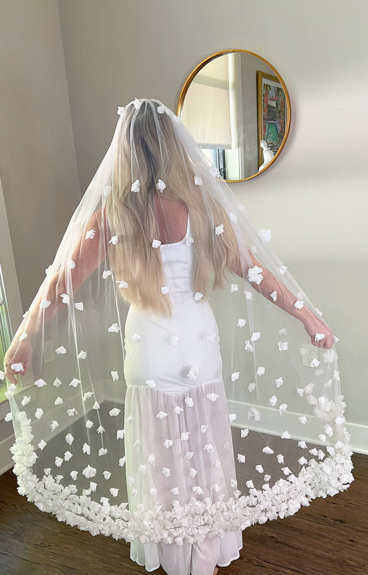 Back view of Knee Length Wedding Veil with White Flowers in bridal showroom.