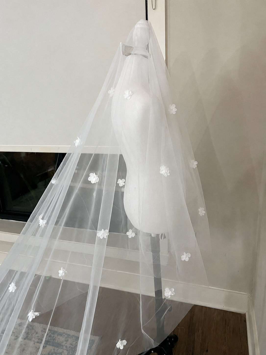 Romantic handmade cathedral wedding veil featuring delicate white 3D floral appliqués on soft illusion tulle. This lightweight single-layer bridal veil creates a beautiful cascading floral effect, perfect for modern, classic, garden, and elegant weddings. Designed by Haus of Lace.