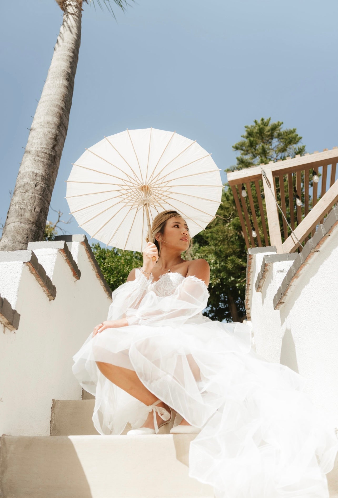 Detachable Flowing Tulle Wedding Train on One of our Brides that got married and she's holding on umbrella