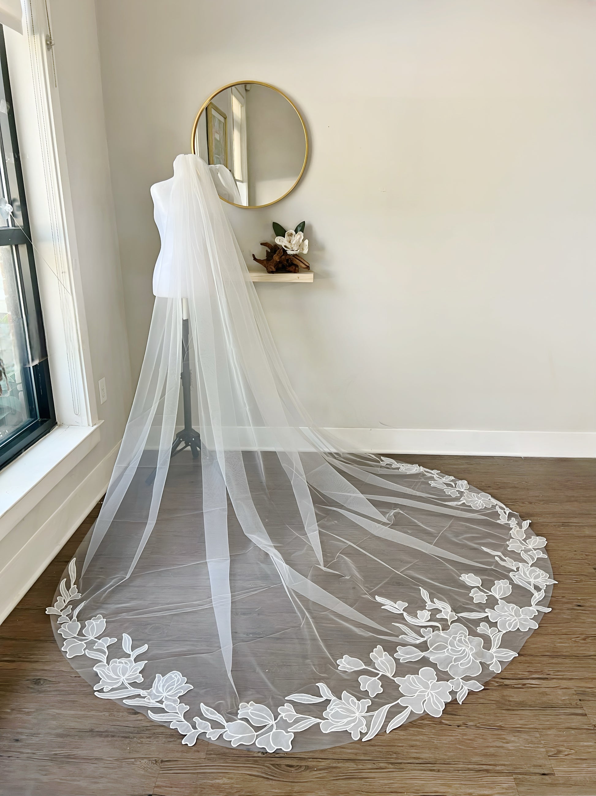 Floor length wedding veil with floral trim in showing room