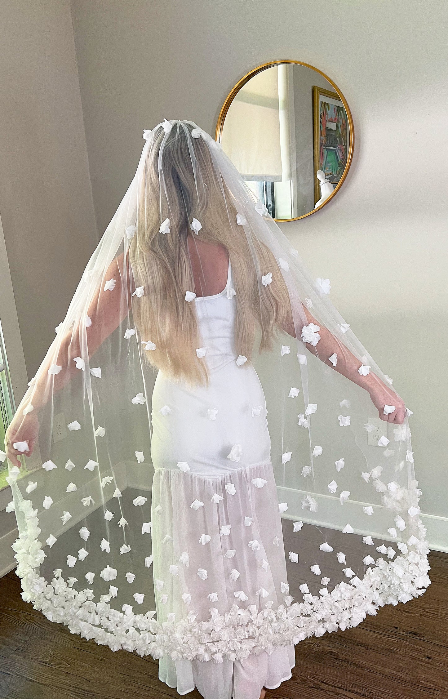 Back view of Knee Length Wedding Veil with White Flowers in bridal showroom.
