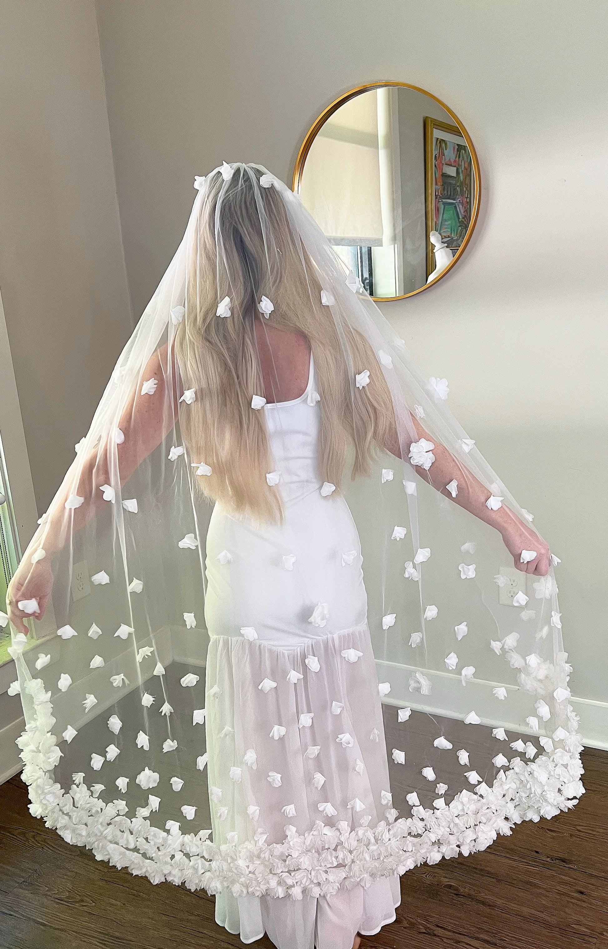 Back view of Knee Length Wedding Veil with White Flowers in bridal showroom.
