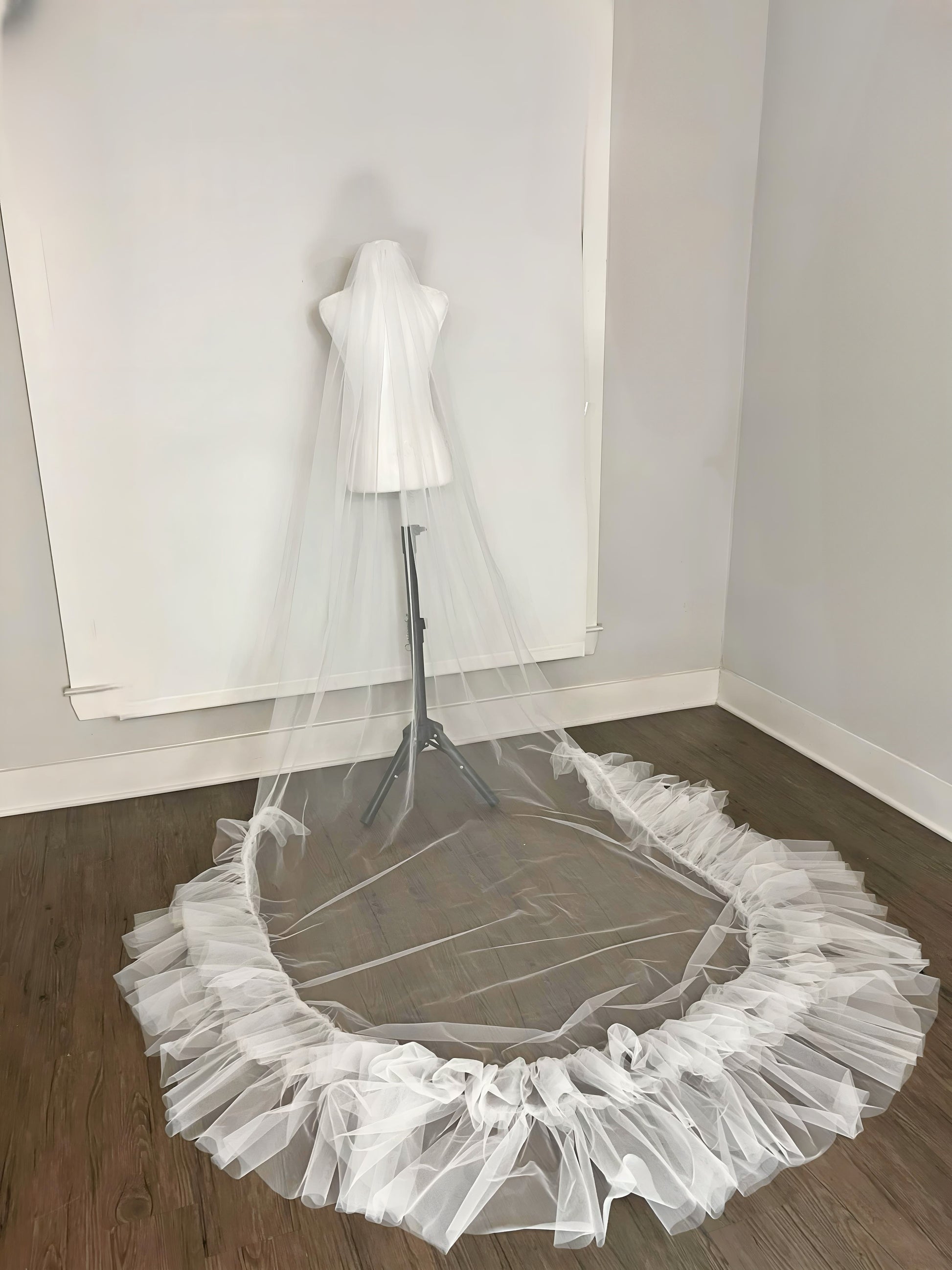 Wedding Veil half ruffles on hardwood floor in showroom. Cathedral length veil